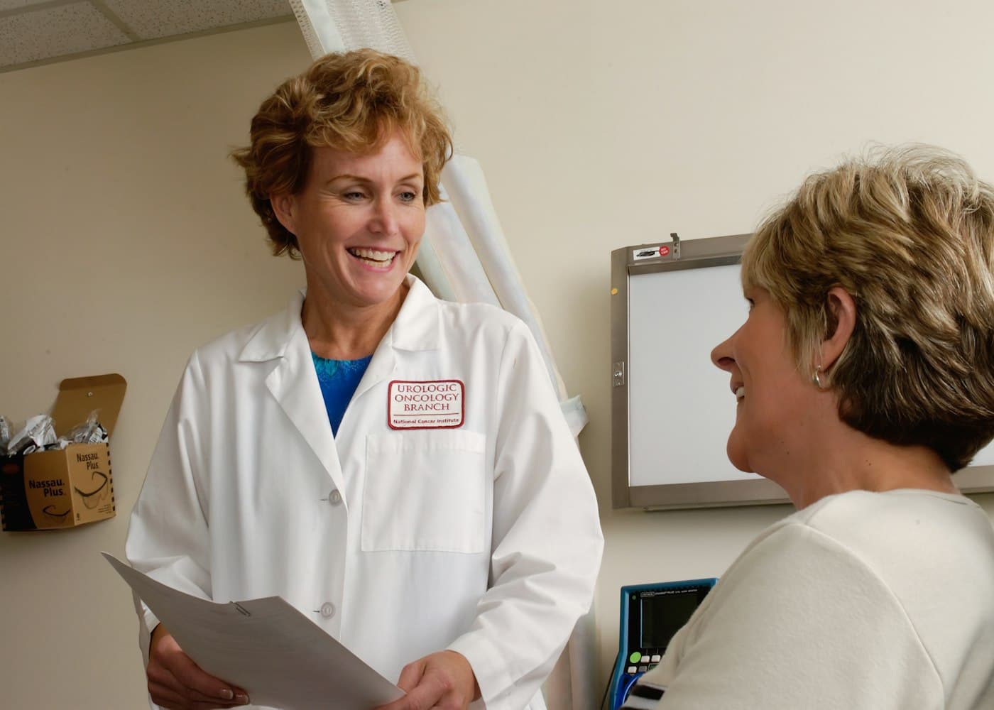 Physician smiling while talking with a patient during a visit